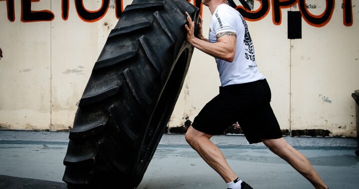 A Crossfit Gym Trainer Flipping Tyre